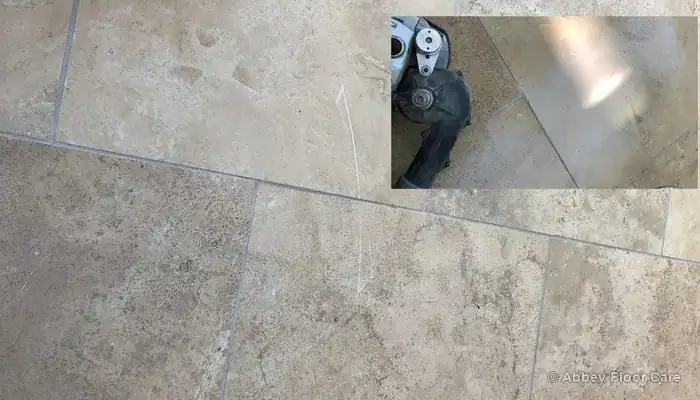 Removing deep scratches using hand honing equipment along the edges of the travertine floor
